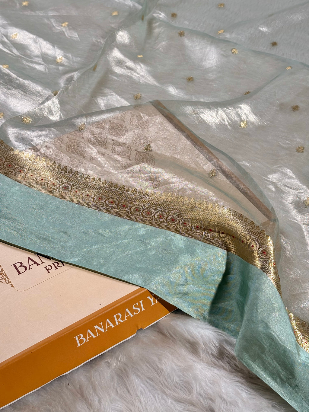 Handwoven pure tishu silk Banarasi saree, meticulously crafted on traditional looms in Varanasi. Features an elegant satin border with intricate weaving.
