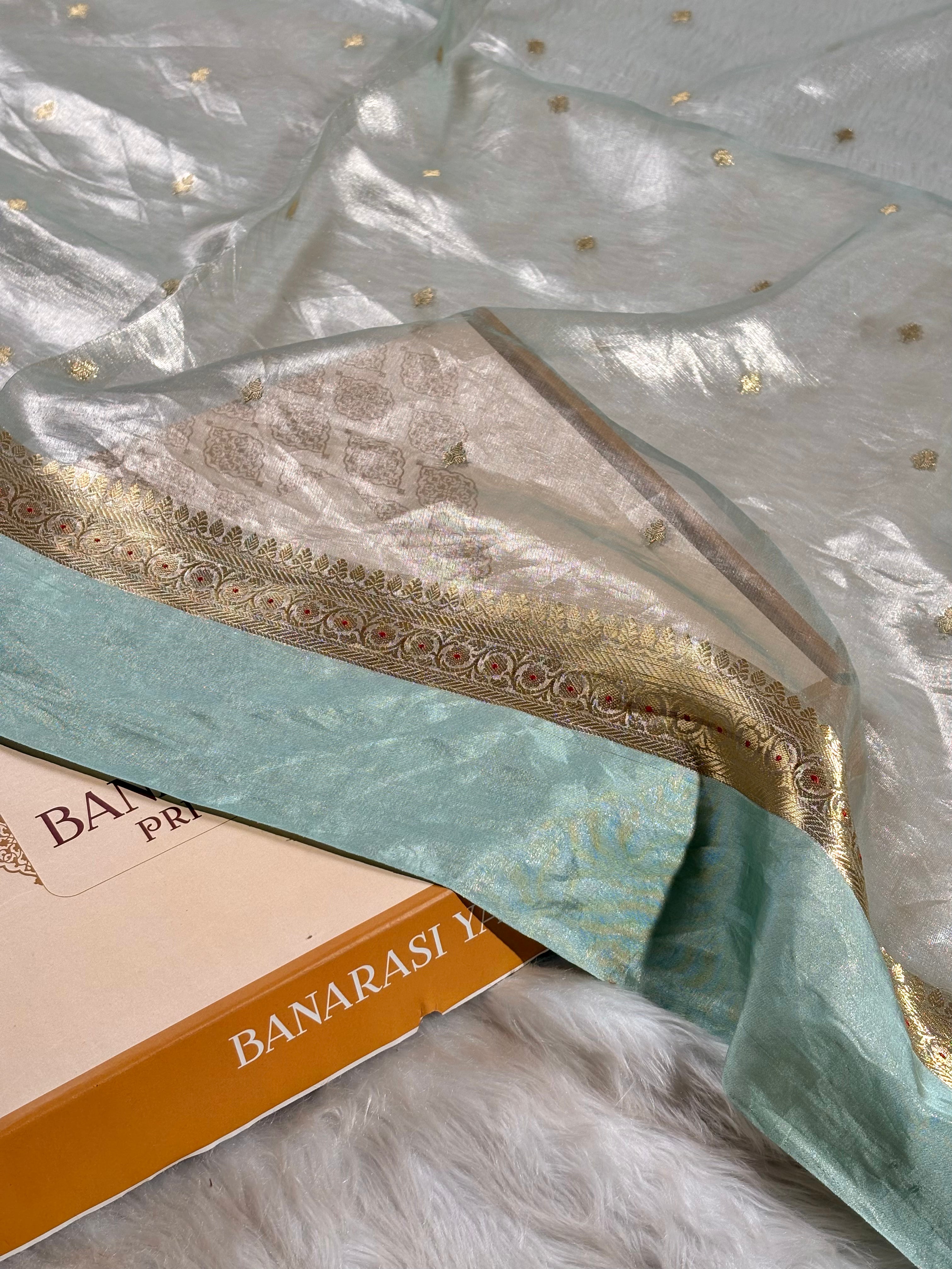 Handwoven pure tishu silk Banarasi saree, meticulously crafted on traditional looms in Varanasi. Features an elegant satin border with intricate weaving.