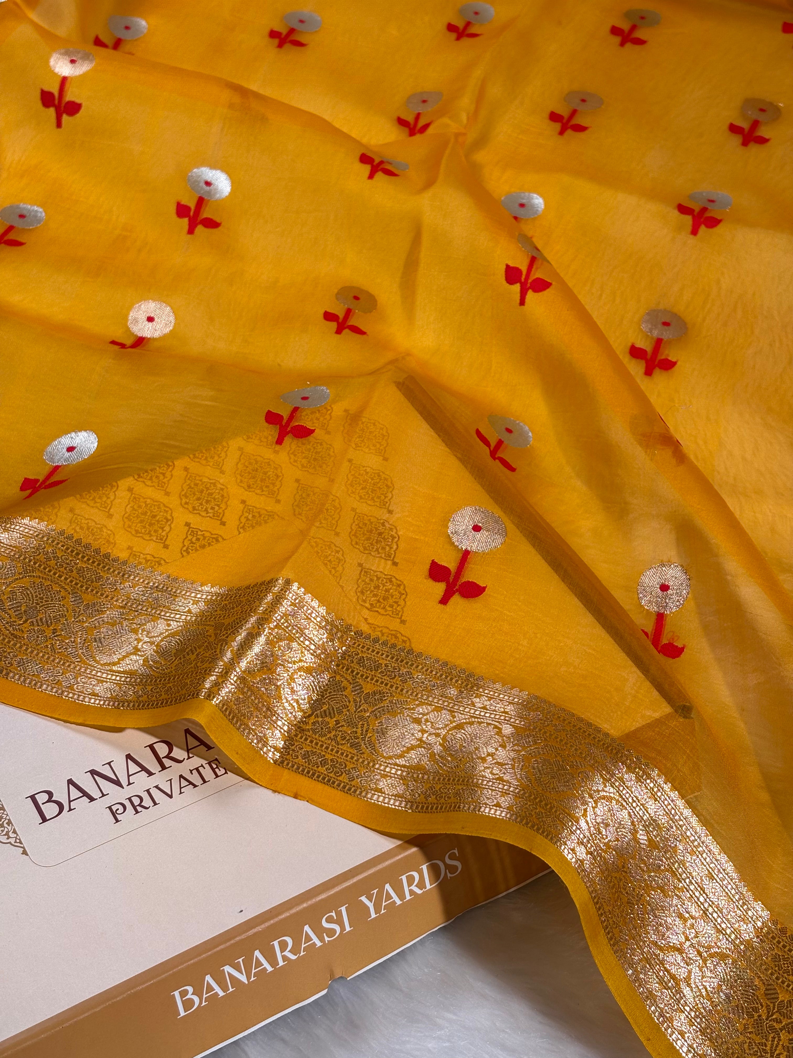 Experience the ethereal elegance of handwoven craftsmanship with this Pure Kora Organza Alfi Banarasi Saree. Meticulously crafted on traditional Varanasi looms, this saree features delicate organza fabric infused with intricate Alfi zari work that catches light with subtle brilliance.