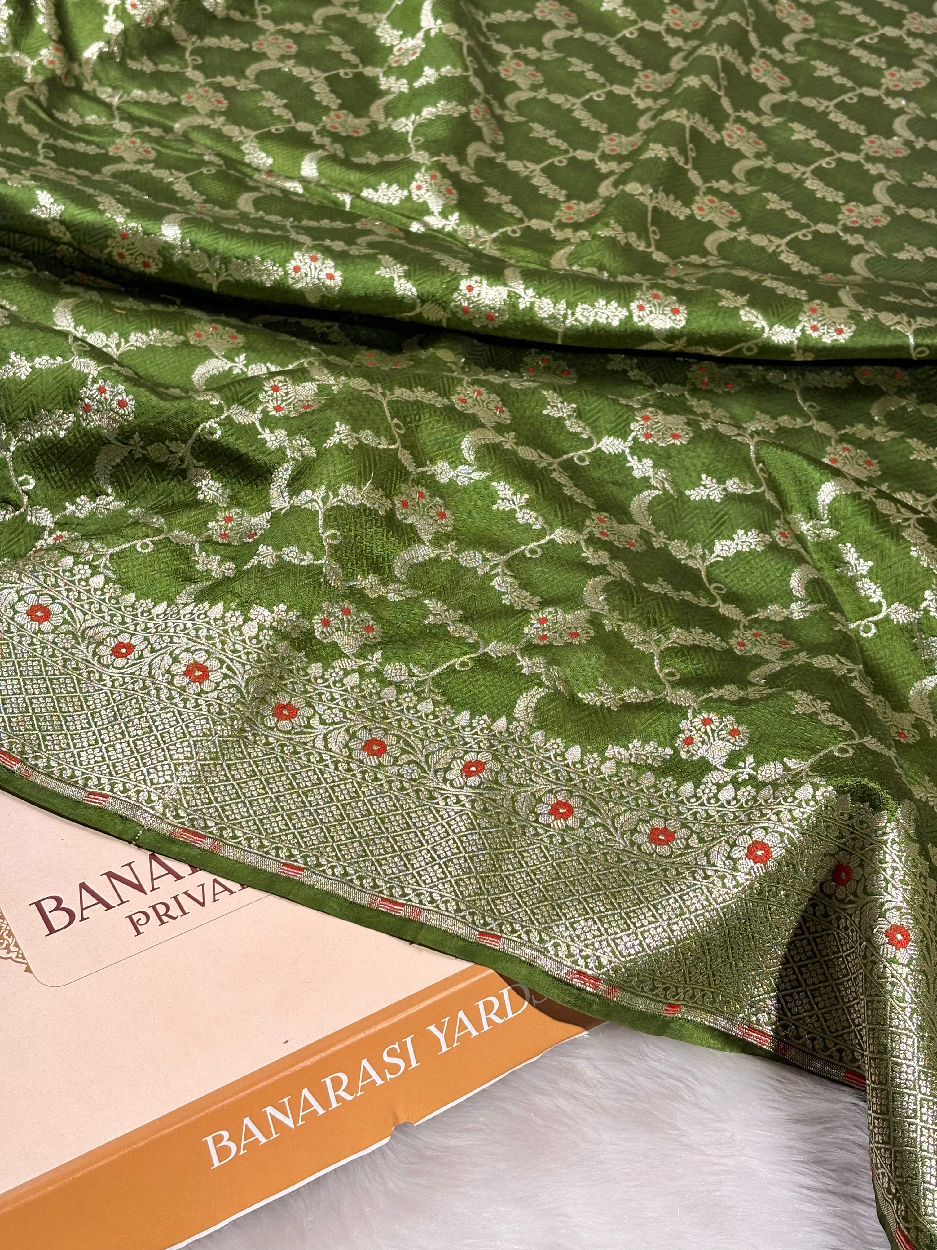 Crafted from lustrous pure katan silk, this saree features intricate mina and zari jaal weaving that creates delicate floral patterns across the saree.