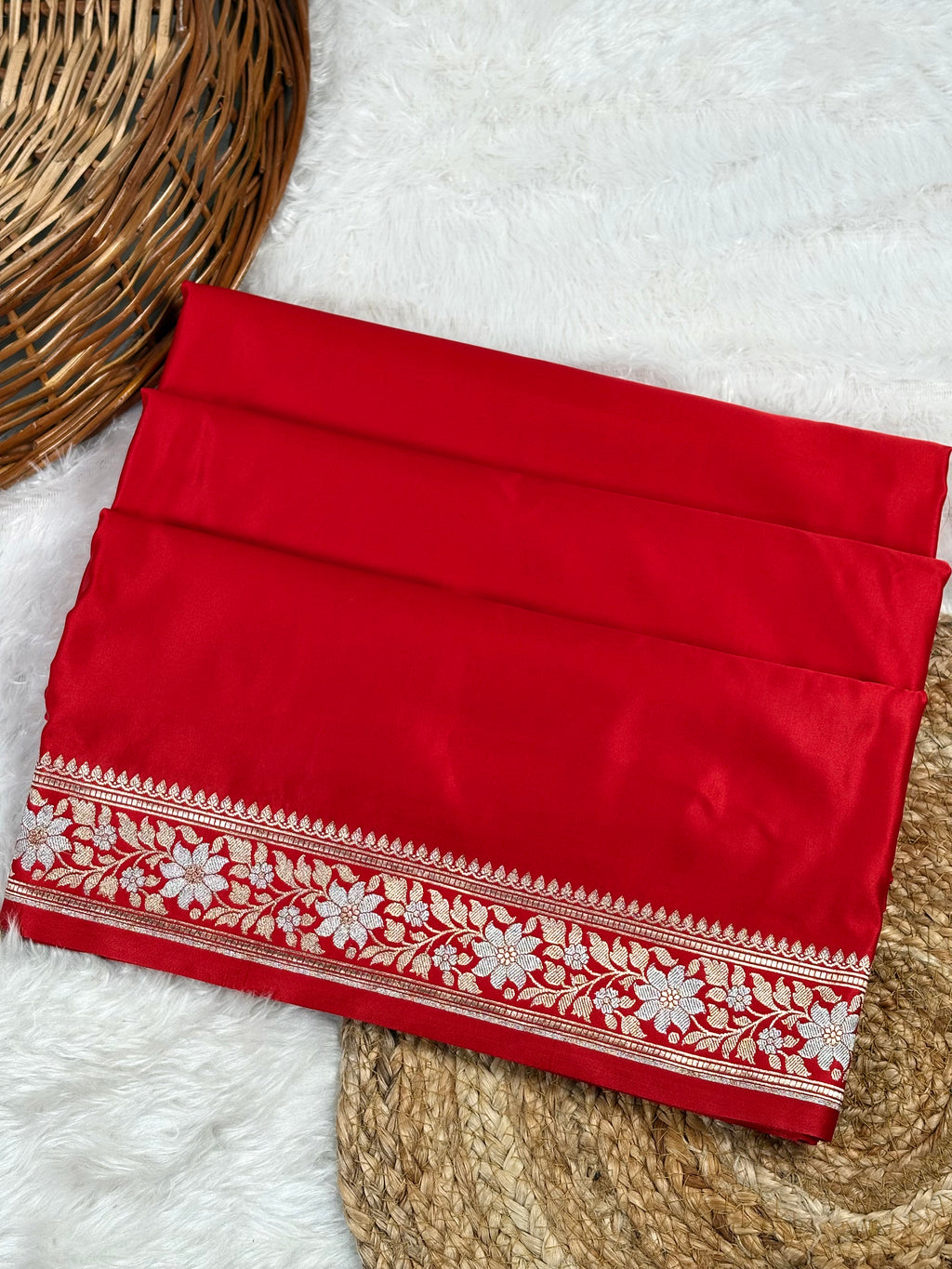 mashru katn banarasi saree, featuring a detailed sona rupa floral border, displayed on a white faux fur rug with a basket.